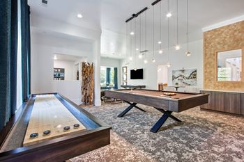 A room with a pool table and a tv.